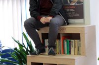 Filip Galko demonštruje, že na knižnici sa dá aj sedieť