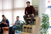 Filip Galko demonštruje, že na knižnici sa dá aj sedieť