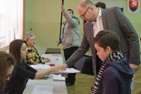 Predseda strany Sloboda a Solidarity Richard Sulík si preberá hlasovacie lístky od členky okrskovej volebnej komisie. Autor foto - Martin Baumann
