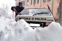 Snehová kalamita v Košiciach 11. februára 1999. Na snímke mestský policajt, ktorý sa snaží spojazdniť služobné auto.