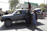 Bojovníci islamistického hnutia Taliban hliadkujú pred prezidentským palácom 16. augusta 2021 v Kábule.