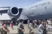 Ľudia bežia okolo amerického transportného lietadla C-17 na medzinárodnom letisku  Hámida Karzaja v Kábule 16. augusta 2021.