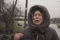 Žena sa prežehnáva na ulici v meste Mariupoľ v Doneckej oblasti na juhovýchode Ukrajiny.