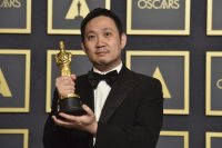 Japonský režisér Rjúsuke Hamaguči pózuje so soškou Oscara za najlepší cudzojazyčný film za snímku Drive My Car